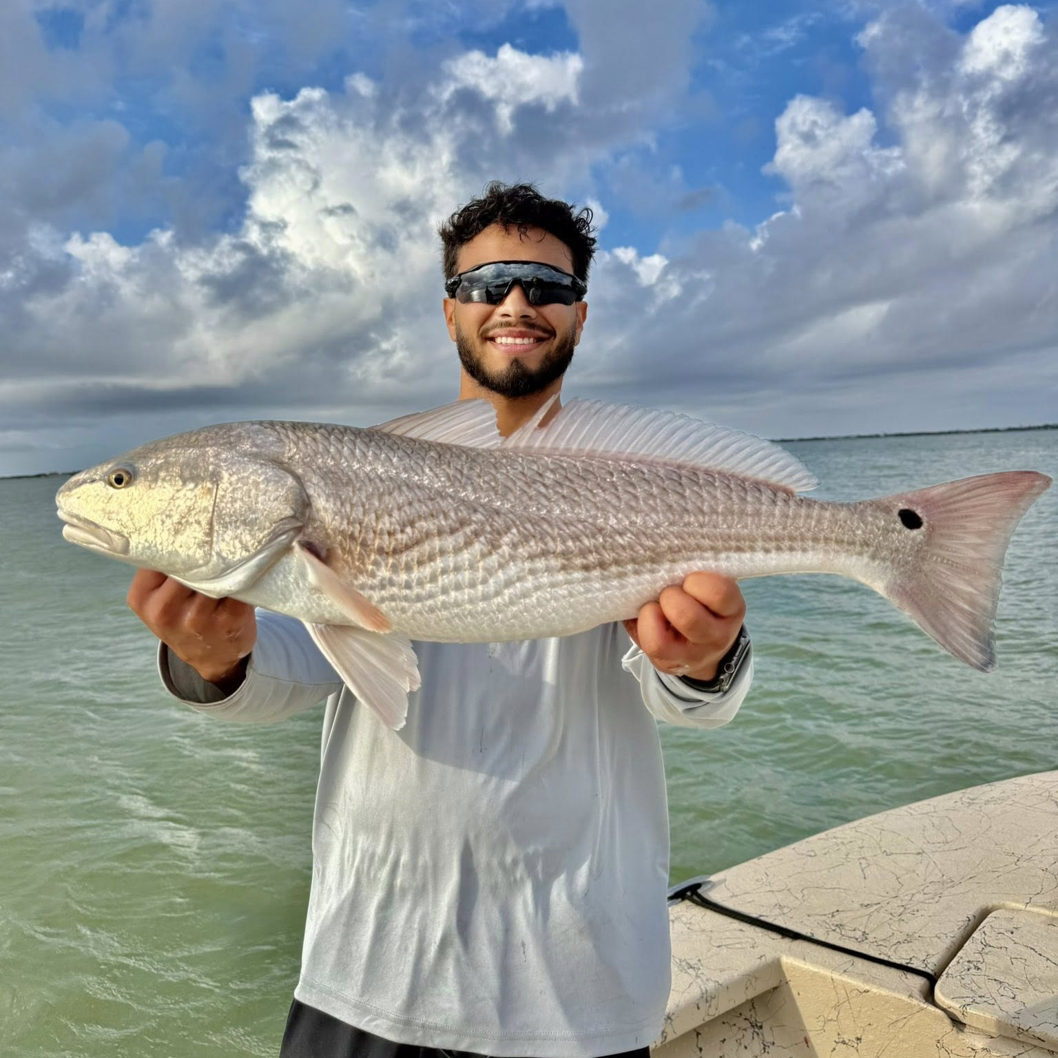 Baffin Bay fishing charter boat with anglers catching trout and redfish using live bait