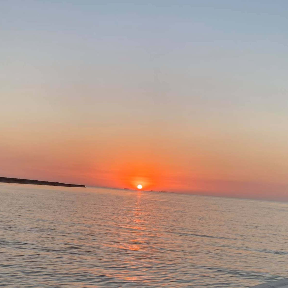 Baffin Bay sunset cruise boat on calm Texas waters with orange sky backdrop