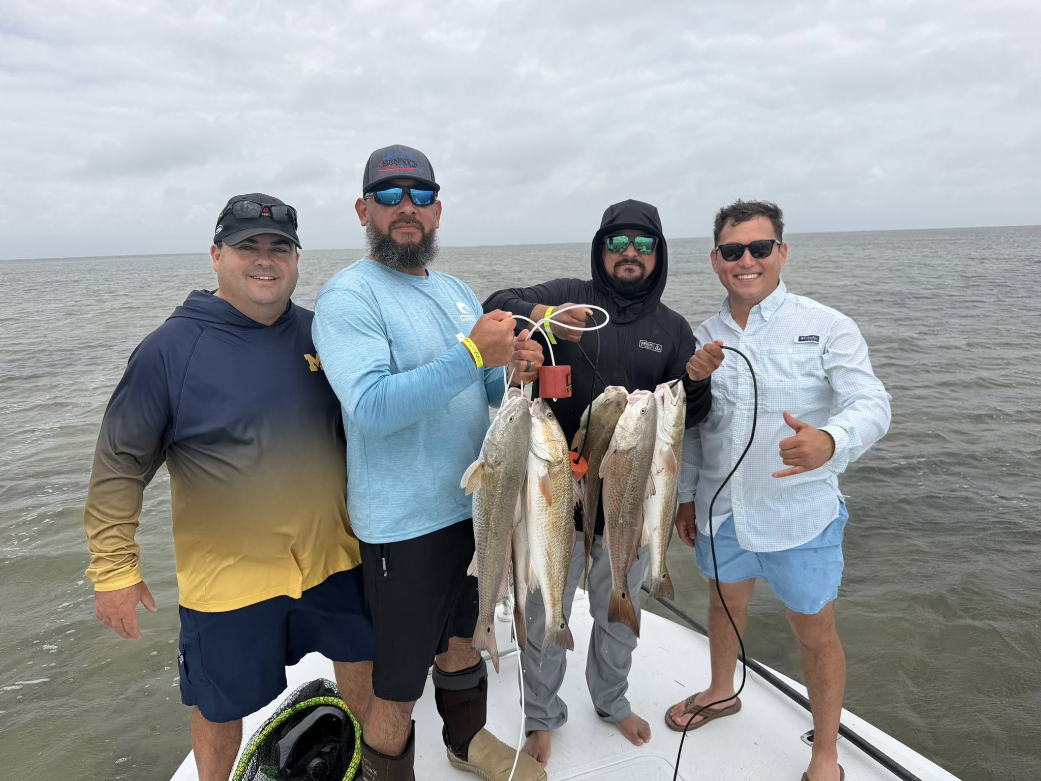 Four anglers display their catch of redfish on a fishing boat in Port Isabel TX