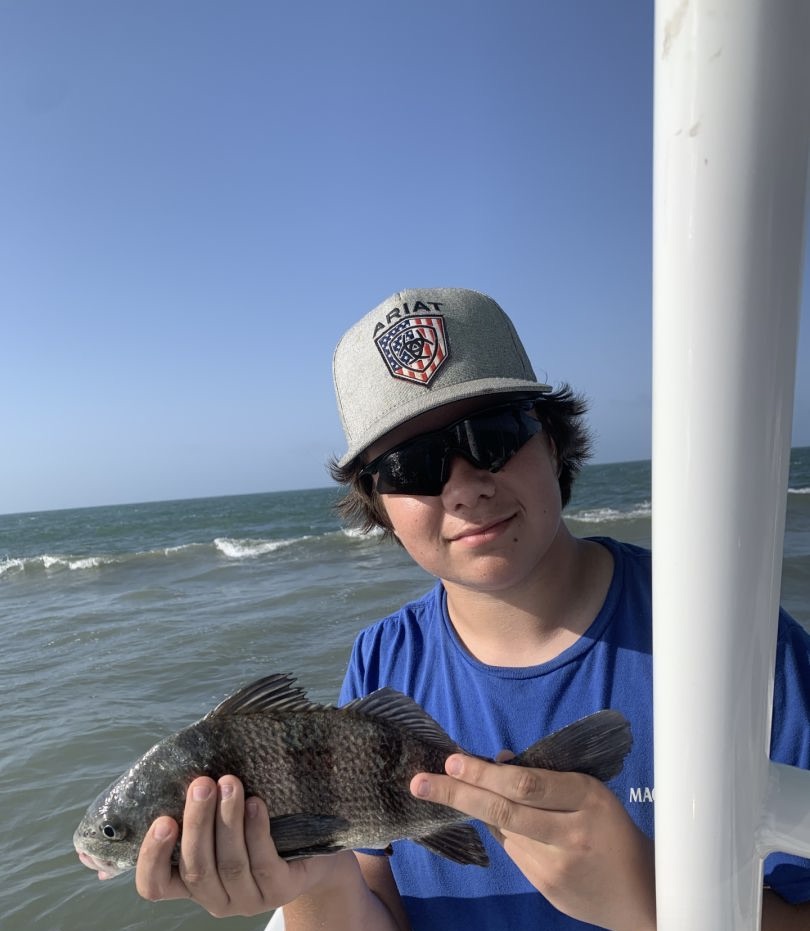 A fisherman catches a black drum in Galveston
