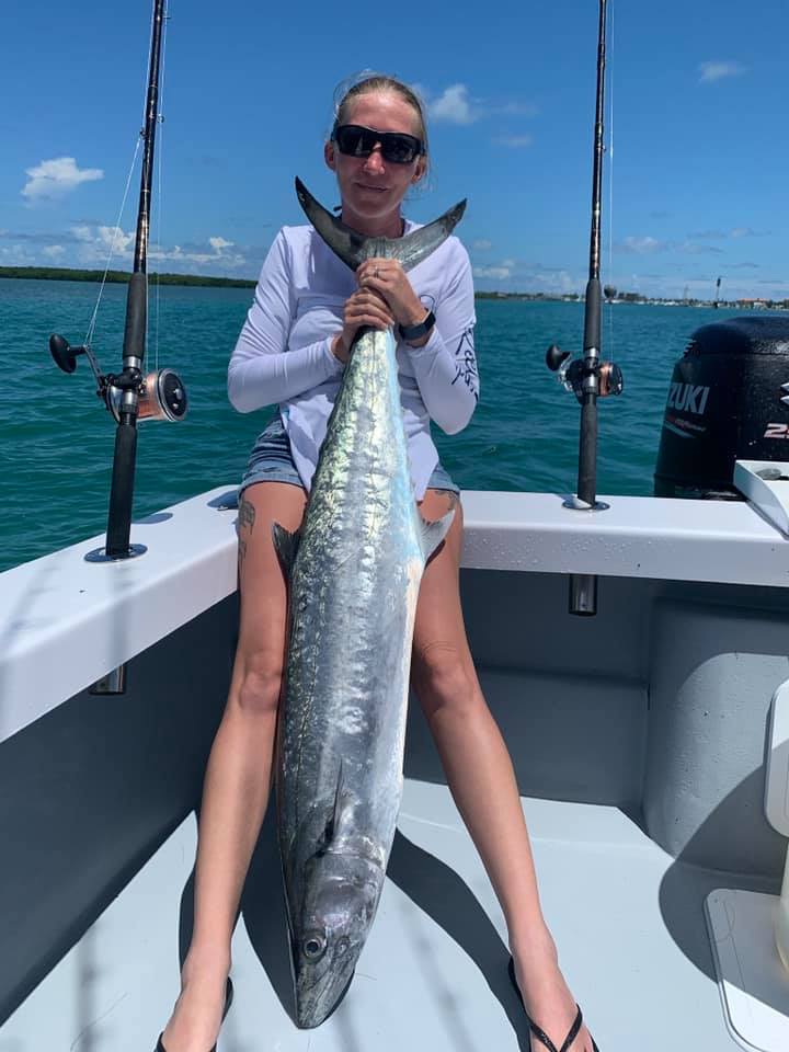 A fisherman holds a large king mackerel caught in Fort Pierce