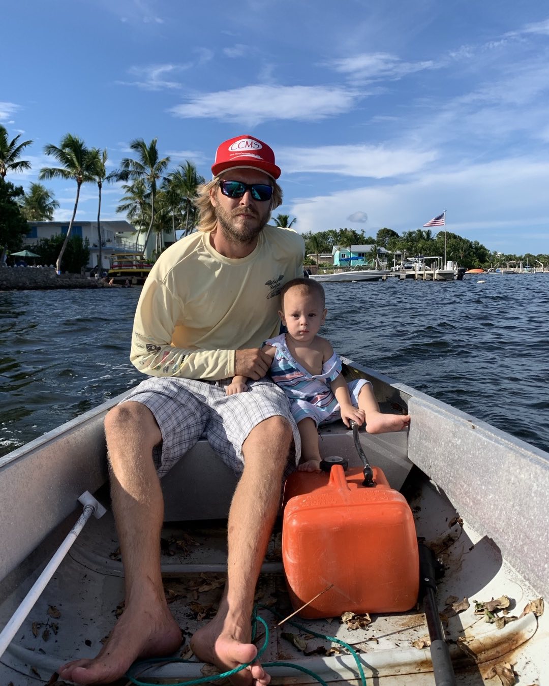 Fishing boat on water in Key Largo FL with palm trees and marina in background