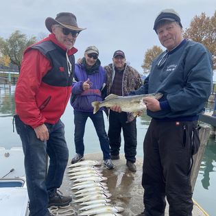 A group of four people fishing with fishing rods in Ontario, Canada.