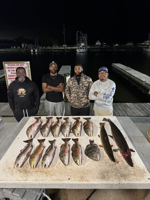 Fresh caught redfish displayed on cleaning table at Lafitte Louisiana marina dock at night
