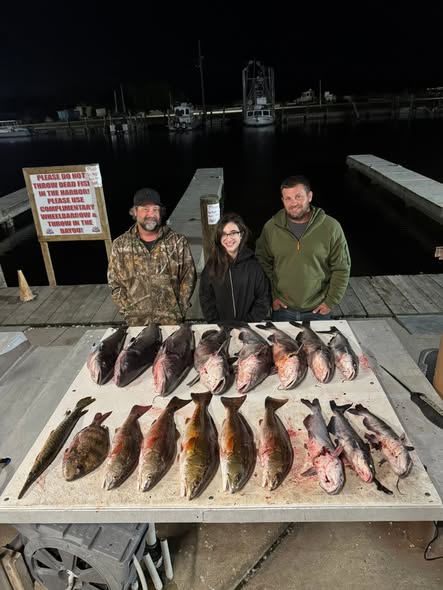 Fishing charter display of fresh caught redfish and other species on dock in Lafitte Louisiana