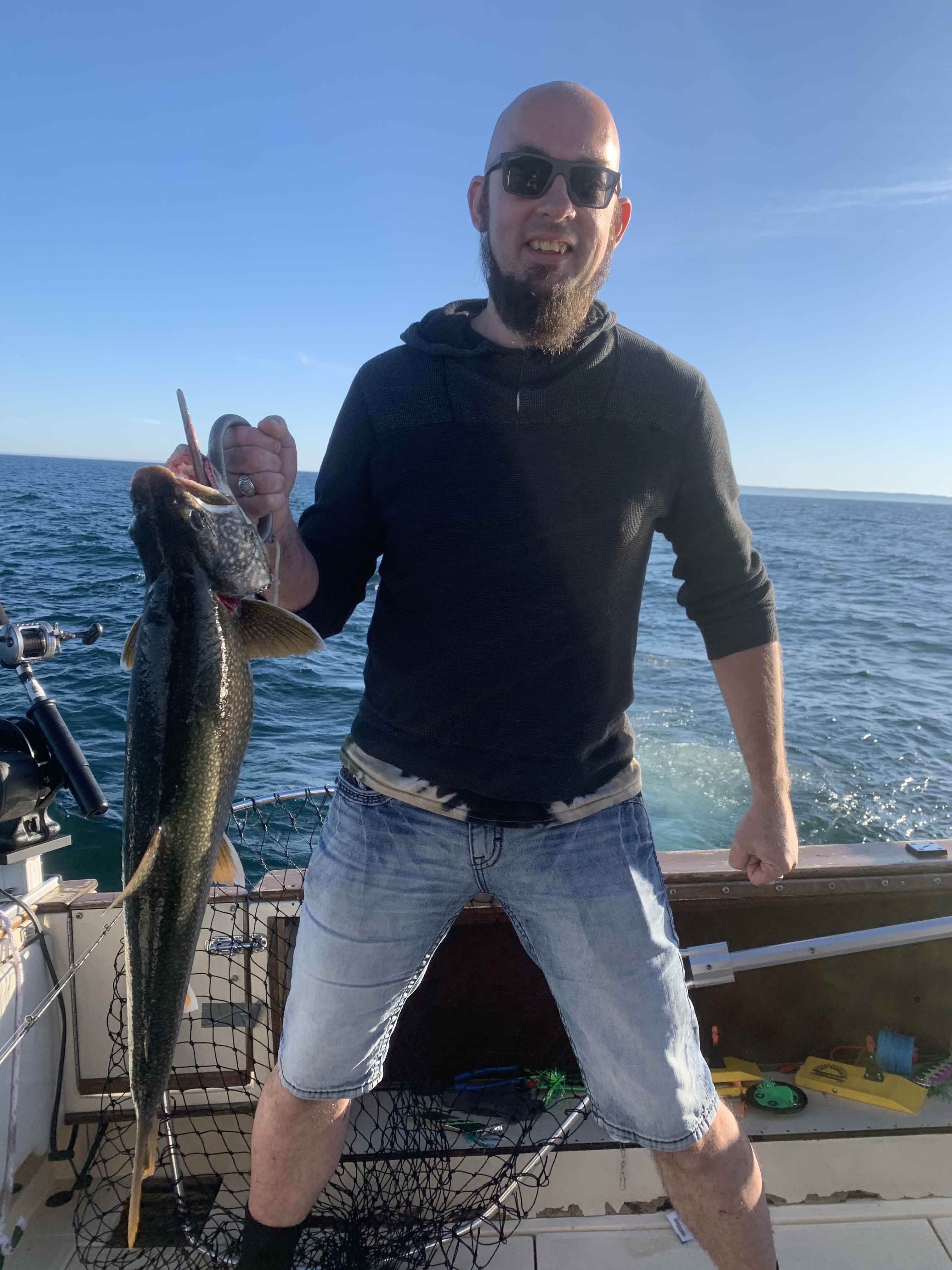 An angler holding a 32-inch fish in Manistee